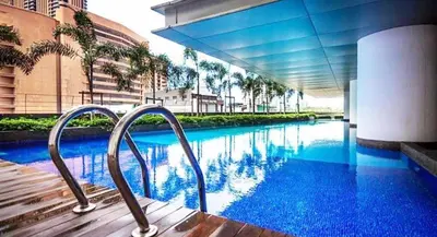 a swimming pool with blue water in a building at Taragon Putri Bintang in Kuala Lumpur