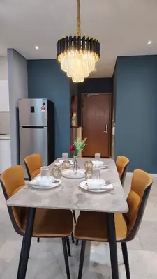 a dining room with a table with chairs and a chandelier at Kuala Lumpur Sky Suites KLCC in Kuala Lumpur