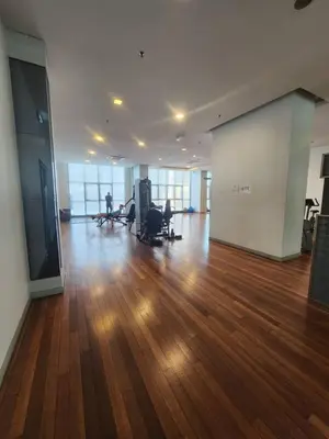 an empty room with a hard wood floor and windows at Infinity Pool Hostel KL in Kuala Lumpur