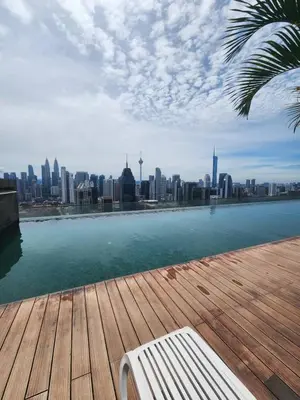 a bench sitting on a wooden deck with a view of a city at Infinity Pool Hostel KL in Kuala Lumpur