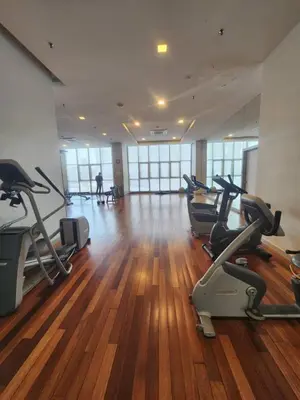 a gym with treadmills and exercise bikes in a room at Infinity Pool Hostel KL in Kuala Lumpur