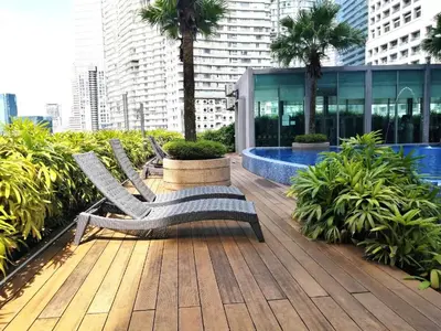 a row of benches sitting on a wooden deck at Majestic Residence Suites KLCC by Homebrickz in Kuala Lumpur