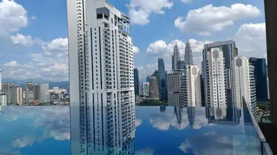 a rendering of a city skyline with a reflection in the water at Majestic Residence Suites KLCC by Homebrickz in Kuala Lumpur