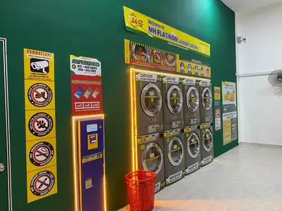 a row of washing machines in a room with a green wall at RSJ Homestay at Setapak - 2 Room in Kuala Lumpur