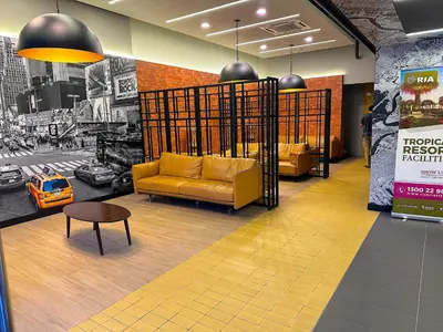 a lobby with a yellow couch and a table at Neu Suites by Serenity Luxe Suites in Kuala Lumpur