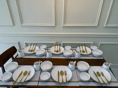 a table topped with white plates and bowls and chopsticks at SV001 Maluri - Sunway Velocity - Cheras Stay in Kuala Lumpur