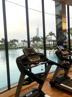 two exercise bikes in a gym with a view of the water at Trion KL SkyLoft in Kuala Lumpur