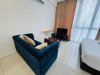 a living room with a blue couch and a bed at KLCC View Serviced Apartment at Majestic Residence Kuala Lumpur in Kuala Lumpur