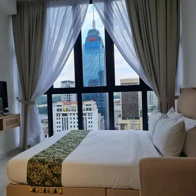 a bed in a room with a large window at KLCC View Serviced Apartment at Majestic Residence Kuala Lumpur in Kuala Lumpur