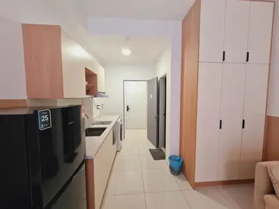 a kitchen with white cabinets and a black refrigerator at KLCC View City Center At Majestic residence in Kuala Lumpur