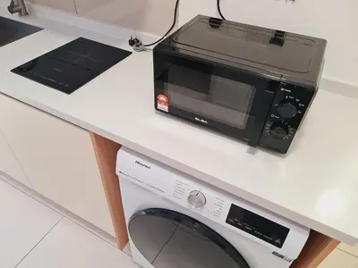 a microwave sitting on a counter next to a washing machine at KLCC View City Center At Majestic residence in Kuala Lumpur