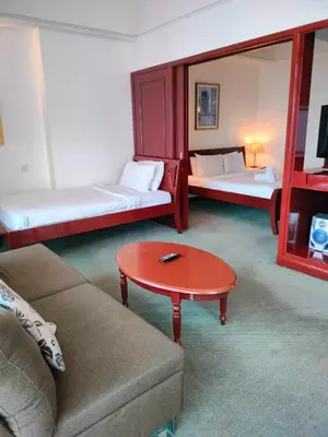 a room with two beds and a table and a couch at Glacier suite at times square kl in Kuala Lumpur