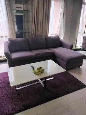 a living room with a purple couch and a coffee table at Glacier suite at times square kl in Kuala Lumpur