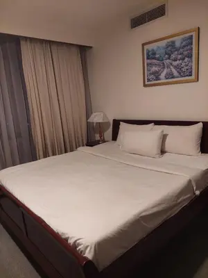 a bedroom with a large bed with white sheets at KL Heart Suite at berjaya Times Square in Kuala Lumpur