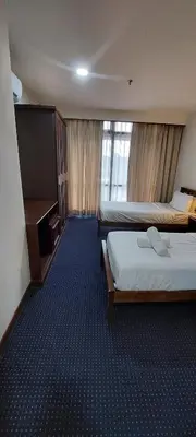 a hotel room with two beds and a television at KL Heart Suite at berjaya Times Square in Kuala Lumpur