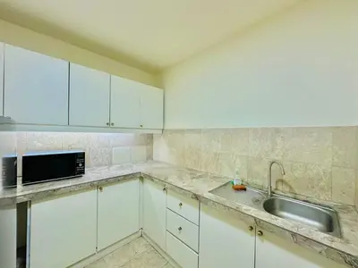 a kitchen with white cabinets and a sink and a microwave at City view Service Residence At Times Square kL in Kuala Lumpur