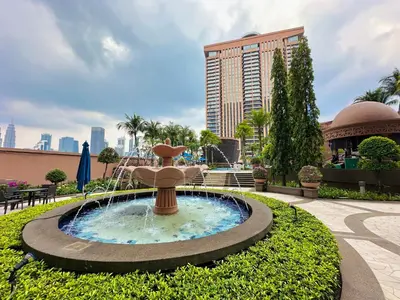 a fountain in a park in front of a building at City view Service Residence At Times Square kL in Kuala Lumpur