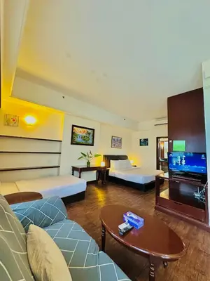 a living room with two beds and a flat screen tv at City view Service Residence At Times Square kL in Kuala Lumpur