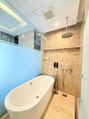 a white tub in a bathroom with blue walls at Dorsett Luxury KLCC by IHG in Kuala Lumpur