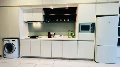 a kitchen with white cabinets and a white refrigerator at The Platinum KLCC By Elegant Suites in Kuala Lumpur