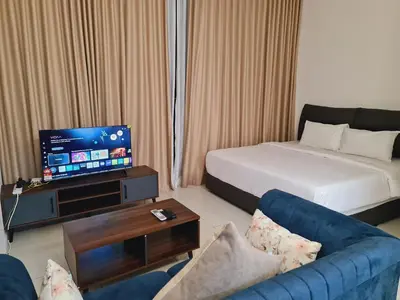 a hotel room with a bed and a couch and a tv at Majestic Residence Kuala Lumpur City Centre in Kuala Lumpur