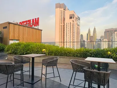 a patio with tables and chairs and a city skyline at Majestic Residence Kuala Lumpur City Centre in Kuala Lumpur