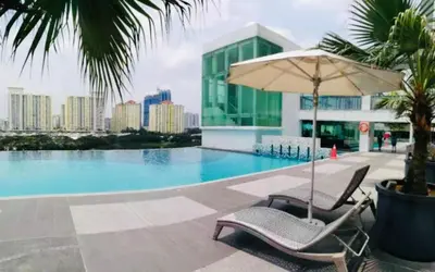 a pair of chairs and an umbrella next to a swimming pool at Setapak Central Mall 2 Bed Zetapark Home Sweet Home in Kuala Lumpur