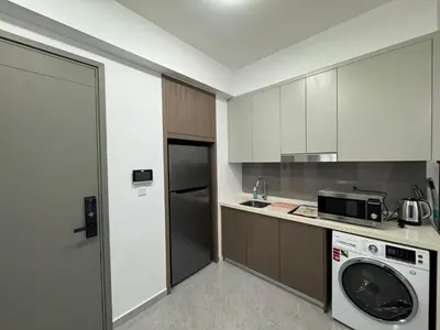 a kitchen with a washing machine and a microwave at KHR Service Suites Agile Bukit Bintang in Kuala Lumpur