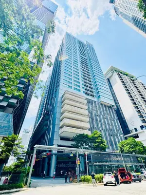 a tall building with cars parked in front of it at The Mercu Summer Suites By Skyline in Kuala Lumpur