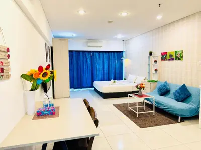 a living room with a blue couch and a table at The Mercu Summer Suites By Skyline in Kuala Lumpur