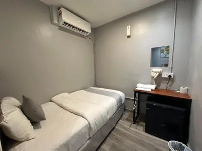 a small room with a bed and a desk at SS Grey House Bukit Bintang KL in Kuala Lumpur