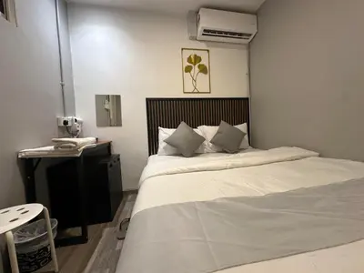 a bedroom with a bed and a desk with a phone at SS Grey House Bukit Bintang KL in Kuala Lumpur