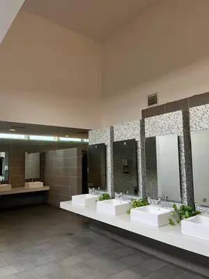 a bathroom with three sinks and two mirrors at Stay Haven at Swiss Garden in Kuala Lumpur