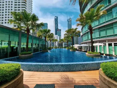 a swimming pool in a city with palm trees and buildings at Newly Renovated 3 Bedroom Vortex Suites KLCC by Tharwa in Kuala Lumpur
