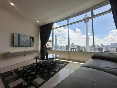 a living room with a couch and a large window at Newly Renovated 3 Bedroom Vortex Suites KLCC by Tharwa in Kuala Lumpur