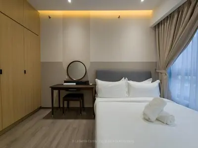 a bedroom with a bed and a desk with a mirror at La Gente x Agile Bukit Bintang TRX Pavilion KL in Kuala Lumpur