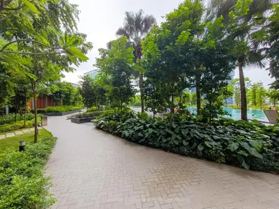 a walkway in a park with trees and bushes at La Gente x Agile Bukit Bintang TRX Pavilion KL in Kuala Lumpur
