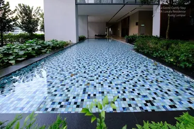 a swimming pool with a tile floor in a building at Luxe Spacious 2BR Condo KLCC 600mbps Full Furnish in Kuala Lumpur