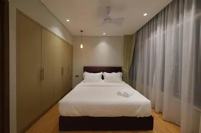 a bedroom with a large white bed and a window at 3R2B SkySuites Next to KLCC Twin Tower High Floor in Kuala Lumpur