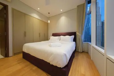a bedroom with a large bed with white sheets at 3R2B SkySuites Next to KLCC Twin Tower High Floor in Kuala Lumpur