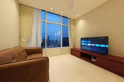 a living room with a couch and a flat screen tv at 3R2B SkySuites Next to KLCC Twin Tower High Floor in Kuala Lumpur