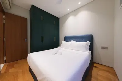 a bedroom with a large white bed with green cabinets at 3R2B SkySuites Next to KLCC Twin Tower High Floor in Kuala Lumpur