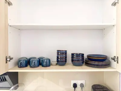 a shelf with blue bowls and plates on it at 3BR Sunway Velocity 2 TRX KLCC in Kuala Lumpur