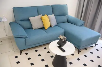 a blue couch in a living room with a table at COZY KenwingstonThe platz Trail 3BR&2BR For 8PAX wifi free Parkin nice view 1902 in Kuala Lumpur