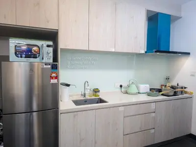 a kitchen with a stainless steel refrigerator and a sink at La Gente Comfy Stay 2R2B Velocity - KL City View in Kuala Lumpur