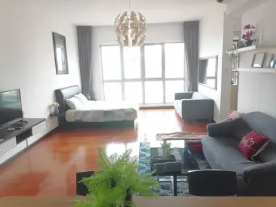a living room with a couch and a tv at REGALIA RESIDENCE KLCC VIEW INFINITY POOL by BT RZQNA in Kuala Lumpur