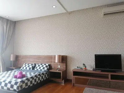 a bedroom with a bed and a flat screen tv at REGALIA RESIDENCE KLCC VIEW INFINITY POOL by BT RZQNA in Kuala Lumpur