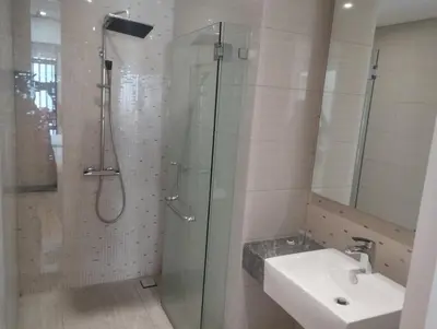 a bathroom with a glass shower and a sink at Anggun Residence by Harmony Home in Kuala Lumpur