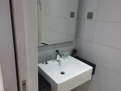 a bathroom with a white sink and a mirror at Anggun Residence by Harmony Home in Kuala Lumpur