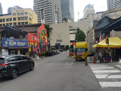 a busy city street with cars and a yellow truck at Anggun Residence by Harmony Home in Kuala Lumpur